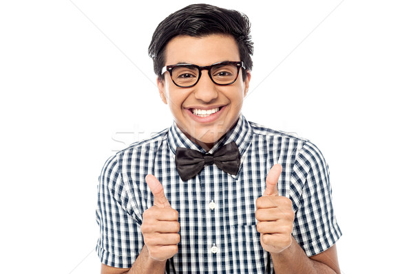 Young man showing double thumbs up Stock photo © stockyimages