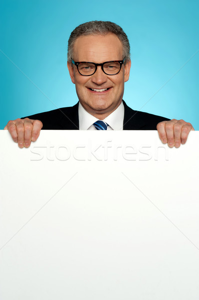 Stock photo: Corporate man standing behind big blank billboard