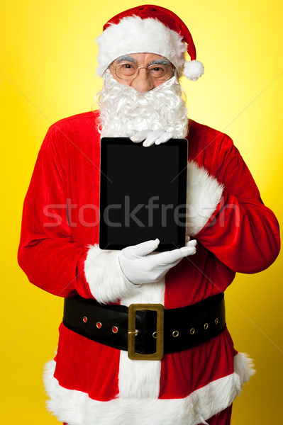 Kris Kringle presenting new updated tablet pc Stock photo © stockyimages