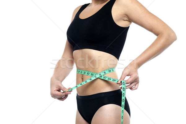 Fit woman measuring her waist, cropped image Stock photo © stockyimages