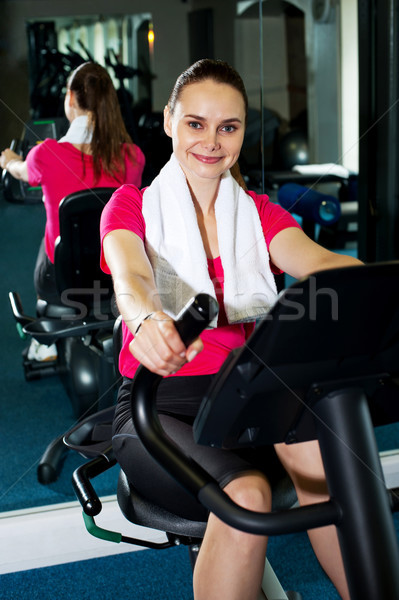Derűs nő biciklizik fitnessz centrum edz Stock fotó © stockyimages