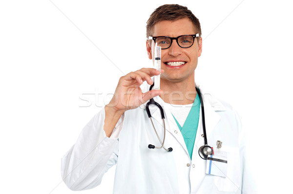 Doctor with an injection needle with white fluid Stock photo © stockyimages