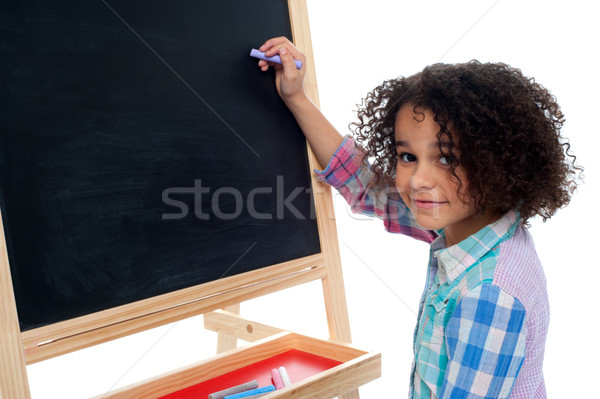 Beautiful little girl writing on classroom board Stock photo © stockyimages