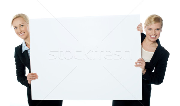 Female business representatives presenting blank banner ad Stock photo © stockyimages