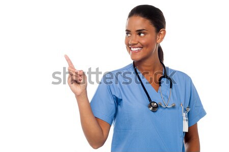 Feminino médico indicação jovem sorridente Foto stock © stockyimages