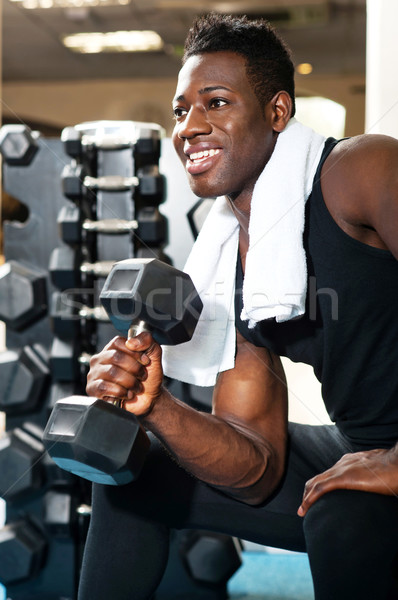 Young gym instructor toning his biceps Stock photo © stockyimages