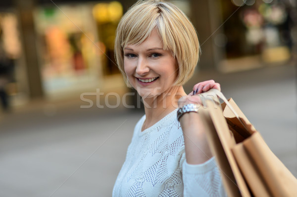 Middle aged woman holding shopping bags Stock photo © stockyimages