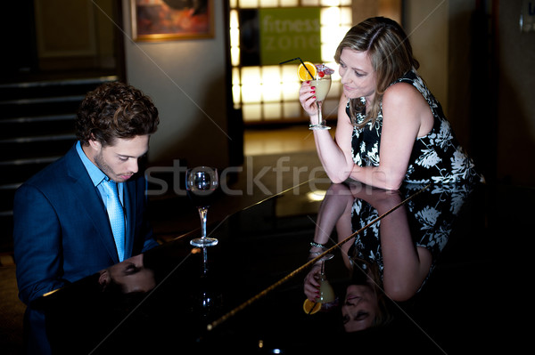 Woman enjoying cocktail and admiring man playing piano Stock photo © stockyimages