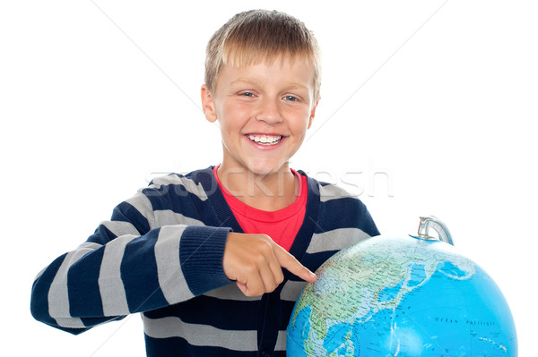 Cute little boy pointing out a continent on the globe Stock photo © stockyimages