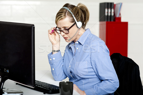 Business lady reviewing report closely Stock photo © stockyimages