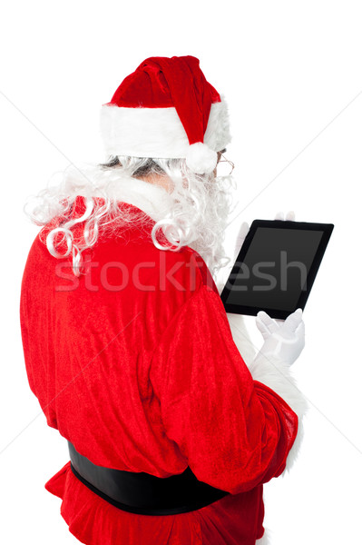 Santa busy in operating tablet pc Stock photo © stockyimages