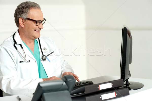 Competente medico lavoro computer sorridere medico di sesso maschile Foto d'archivio © stockyimages