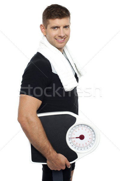 Healthy young man with a weight scale Stock photo © stockyimages