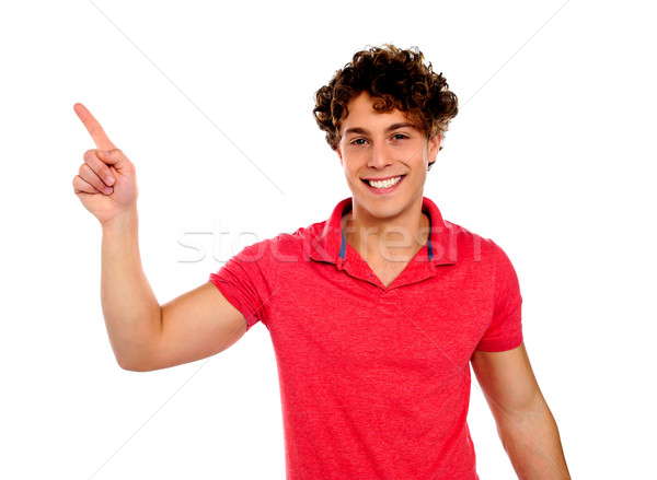 Handsome young teenager in casuals pointing away Stock photo © stockyimages