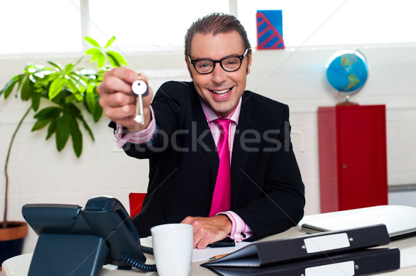 Happy male executive handing over the keys Stock photo © stockyimages