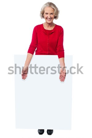 Joyous lady standing behind blank banner ad Stock photo © stockyimages