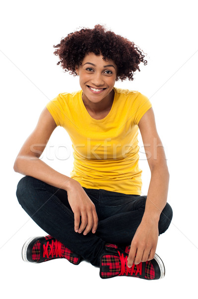 Sorridente senhora sessão as pernas cruzadas piso isolamento Foto stock © stockyimages