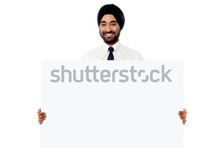 Smiling young man holding white sign board Stock photo © stockyimages