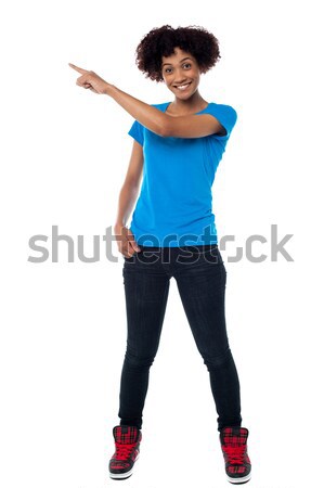 Attractive young woman pointing sideways Stock photo © stockyimages