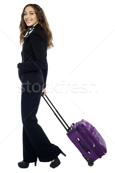 Shot of a brunette dragging her strolley Stock photo © stockyimages