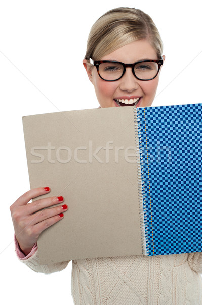 Excited teen girl holding note book close to her Stock photo © stockyimages