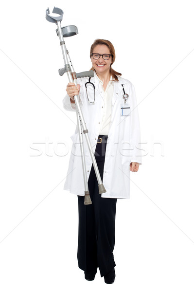 Happy doctor posing with crutches in hand Stock photo © stockyimages