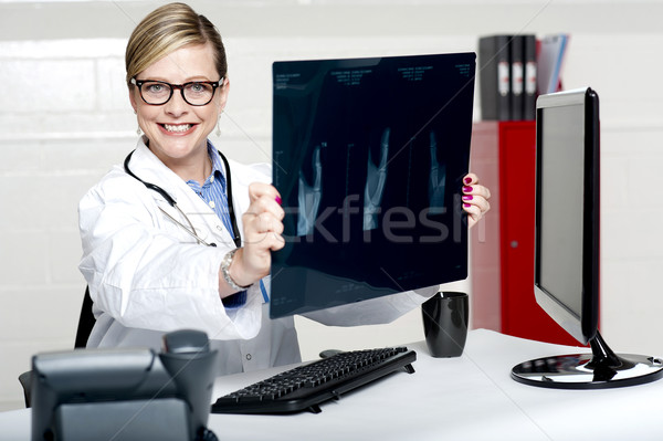 Experienced female physician holding x-ray Stock photo © stockyimages