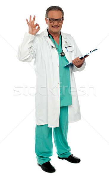Male physician with excellent gesture holding clipboard Stock photo © stockyimages