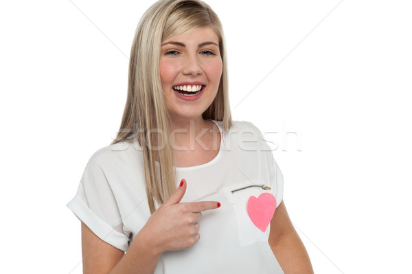Pretty teen pointing towards pink paper heart Stock photo © stockyimages