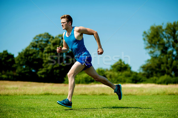 Fit athlete running hard on a sunny day Stock photo © stockyimages