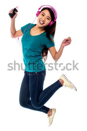 College girl enjoying music through headphones Stock photo © stockyimages