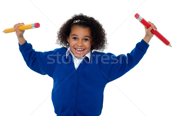 Fun loving elementary girl dancing with pencils in both her hands Stock photo © stockyimages