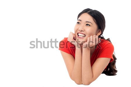 Girl lying on studio floor and thinking something Stock photo © stockyimages