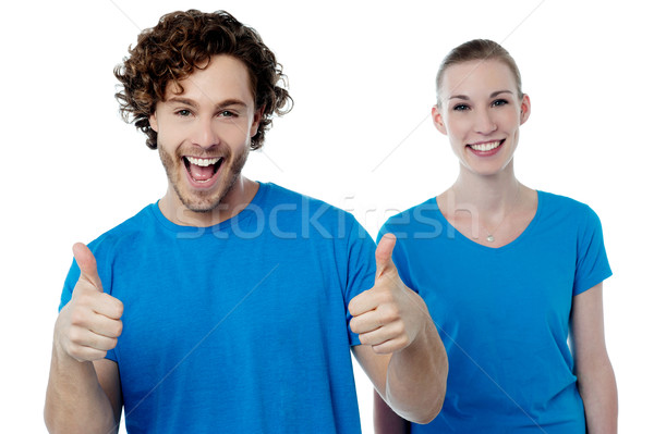 Cheerful couple holding thumbs up Stock photo © stockyimages