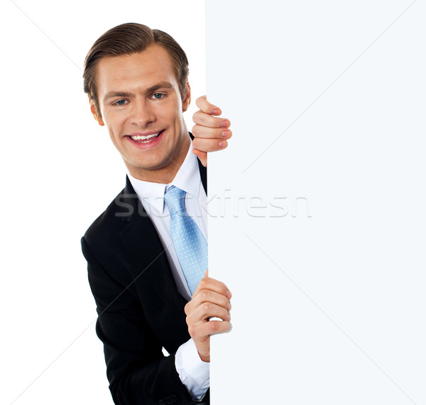 Smiling business professional behind blank clipboard Stock photo © stockyimages