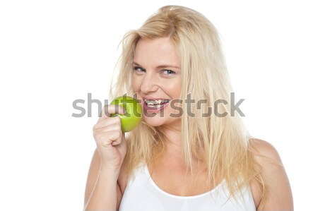Health conscious woman about to take bite from green apple Stock photo © stockyimages