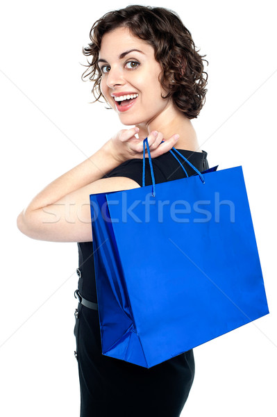 Stock photo: Joyous woman posing with a shopping bag