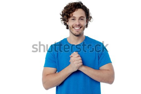 Happy young man with clasped hands Stock photo © stockyimages