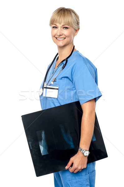Nurse holding x-ray sheet to be passed up to a senior doctor Stock photo © stockyimages
