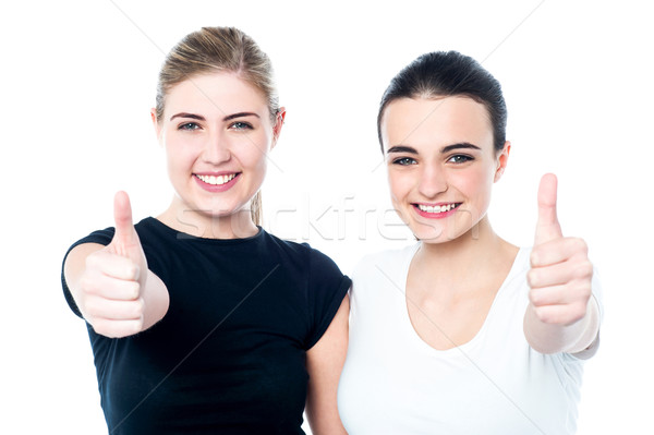Two girls cheering via with thumbs up gesture Stock photo © stockyimages