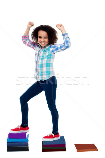 Active girl kid climbing on notebooks Stock photo © stockyimages