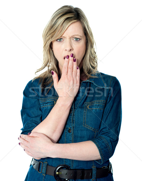 Pretty woman with hand over mouth Stock photo © stockyimages