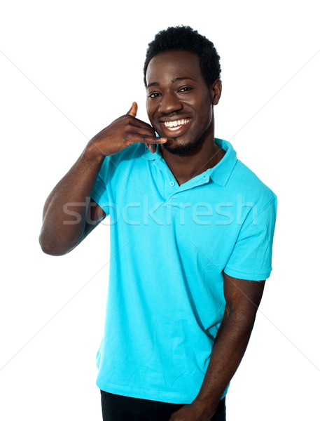 Glimlachend jonge man tonen roepen gebaar geïsoleerd Stockfoto © stockyimages
