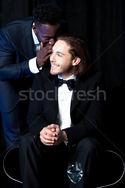 Male secretary sharing secret with his boss Stock photo © stockyimages