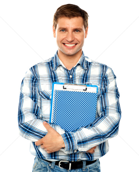 Young man holding clipboard and notepad Stock photo © stockyimages