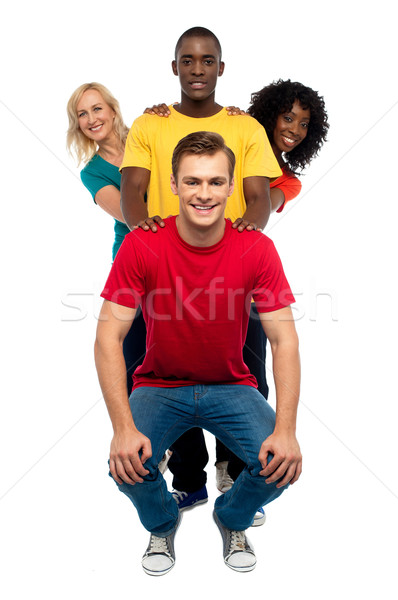 Young people standing behind semi seated guy Stock photo © stockyimages