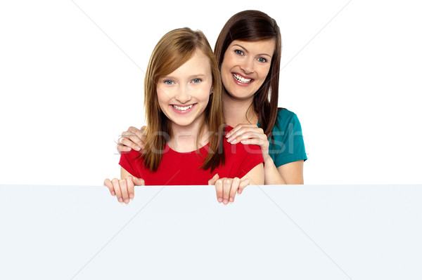 Girl holding ad board with her mother behind her Stock photo © stockyimages