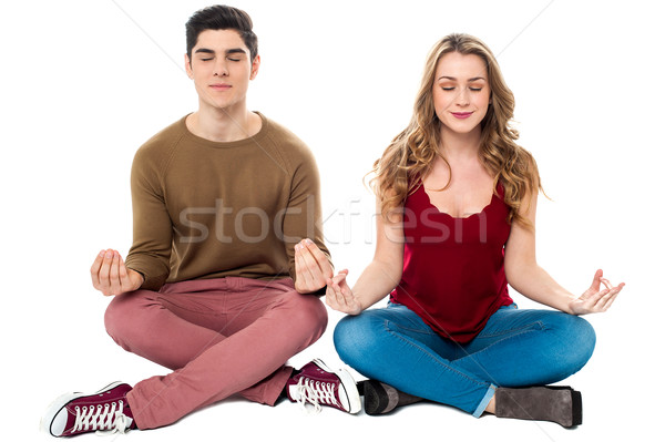Friends meditating in lotus pose, peace of mind Stock photo © stockyimages