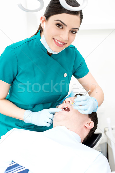 Female dentist examines a patient Stock photo © stockyimages