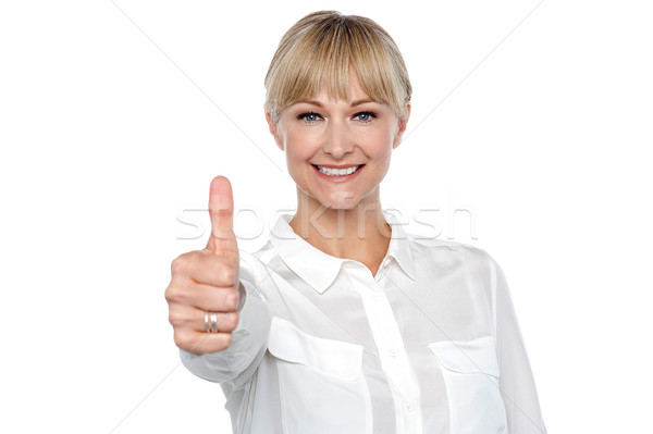 Stock photo: Blonde woman in formal attire showing thumbs up gesture